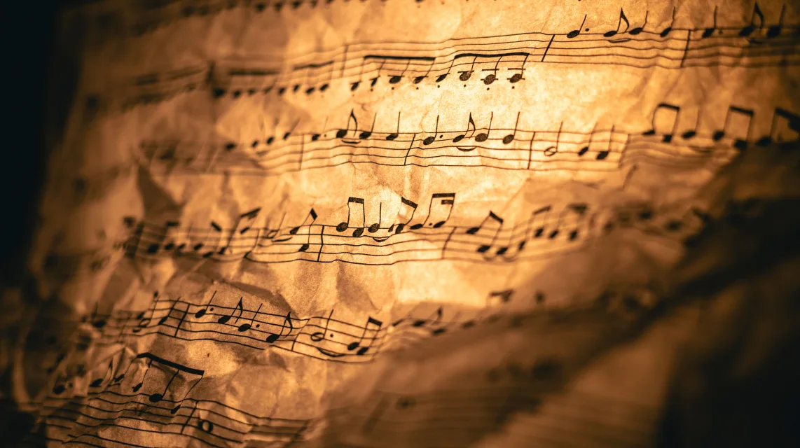 Close-up of sheet music under warm light