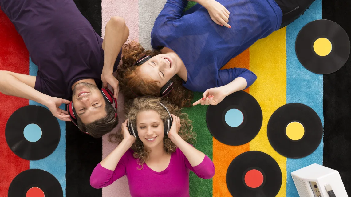 Three friends listening to records together at home