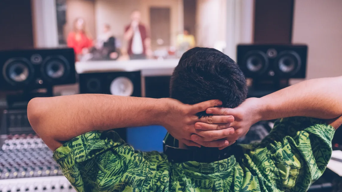 Sound engineer checking a mix at the console in a recording studio