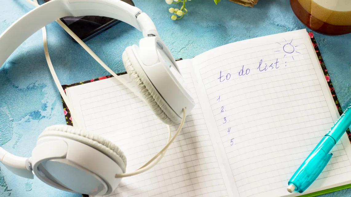 Smartphone and headphones on a desk, as seen when searching for a song