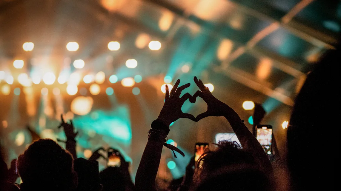 Large crowd with raised hands at a live concert